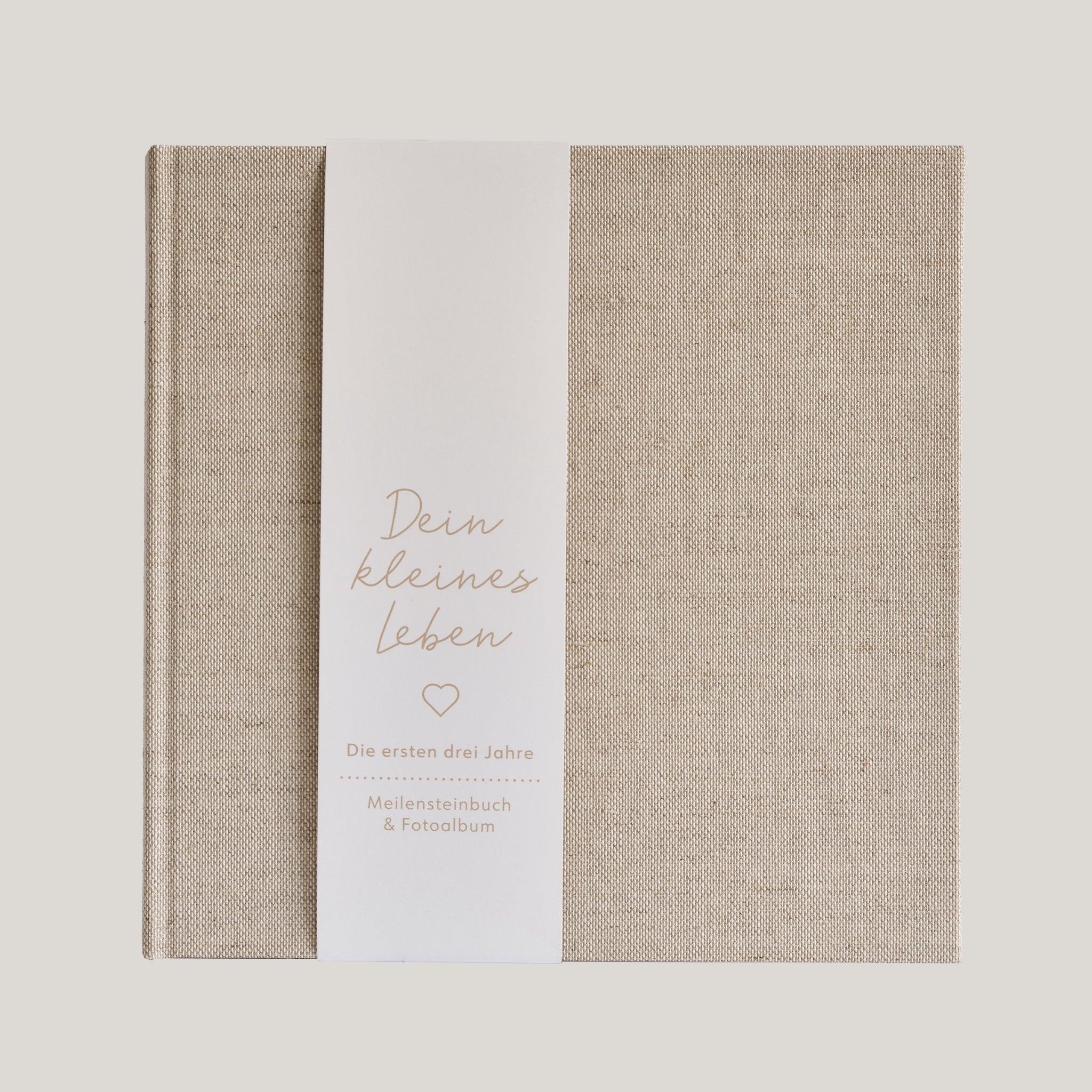 Babybuch aus Leinenstoff mit Papierbanderole mit der Aufschrift "Dein kleines Leben"