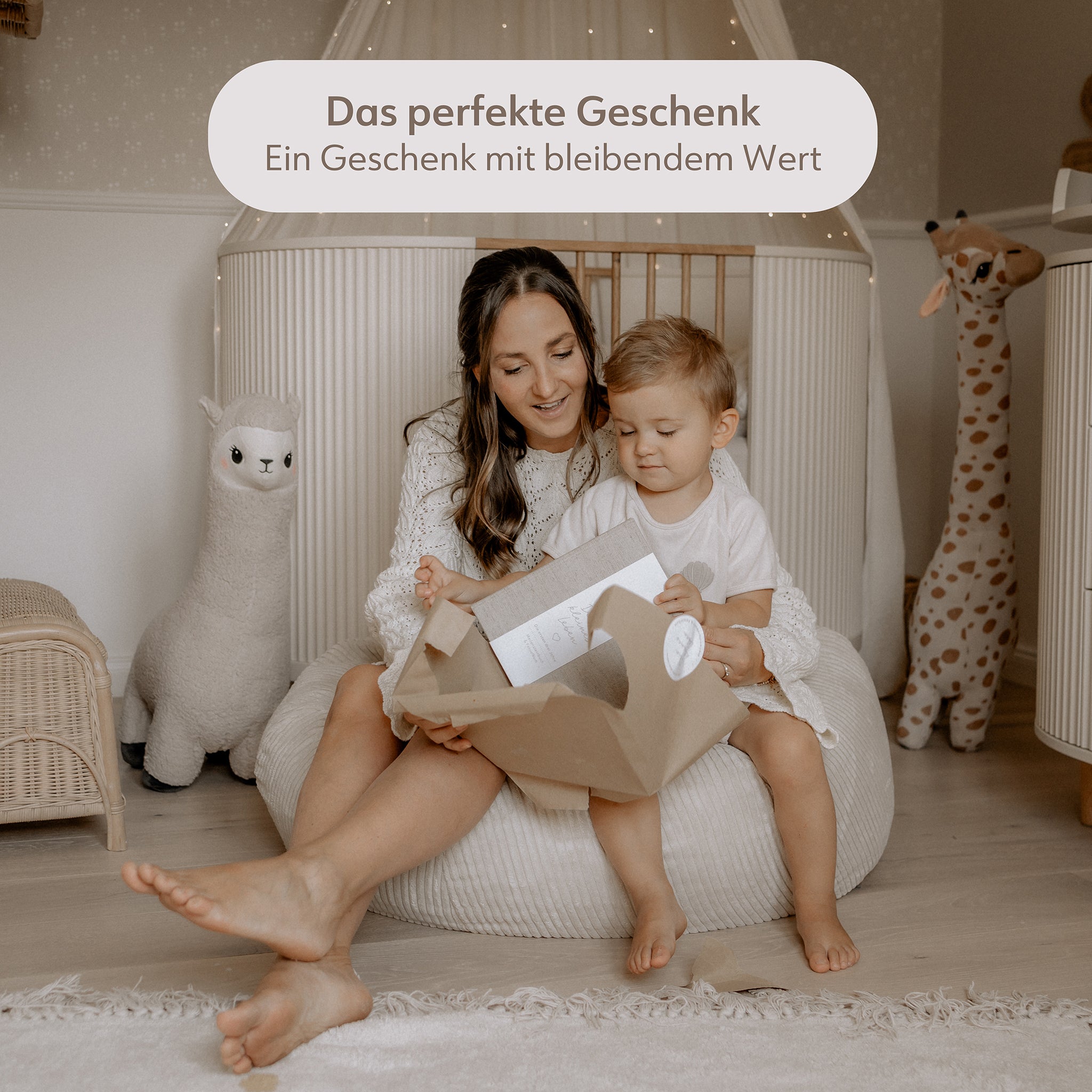 Mama und Sohn packen ein Geschenk aus. Dabei handelt es sich um das Babybuch dein kleines Leben