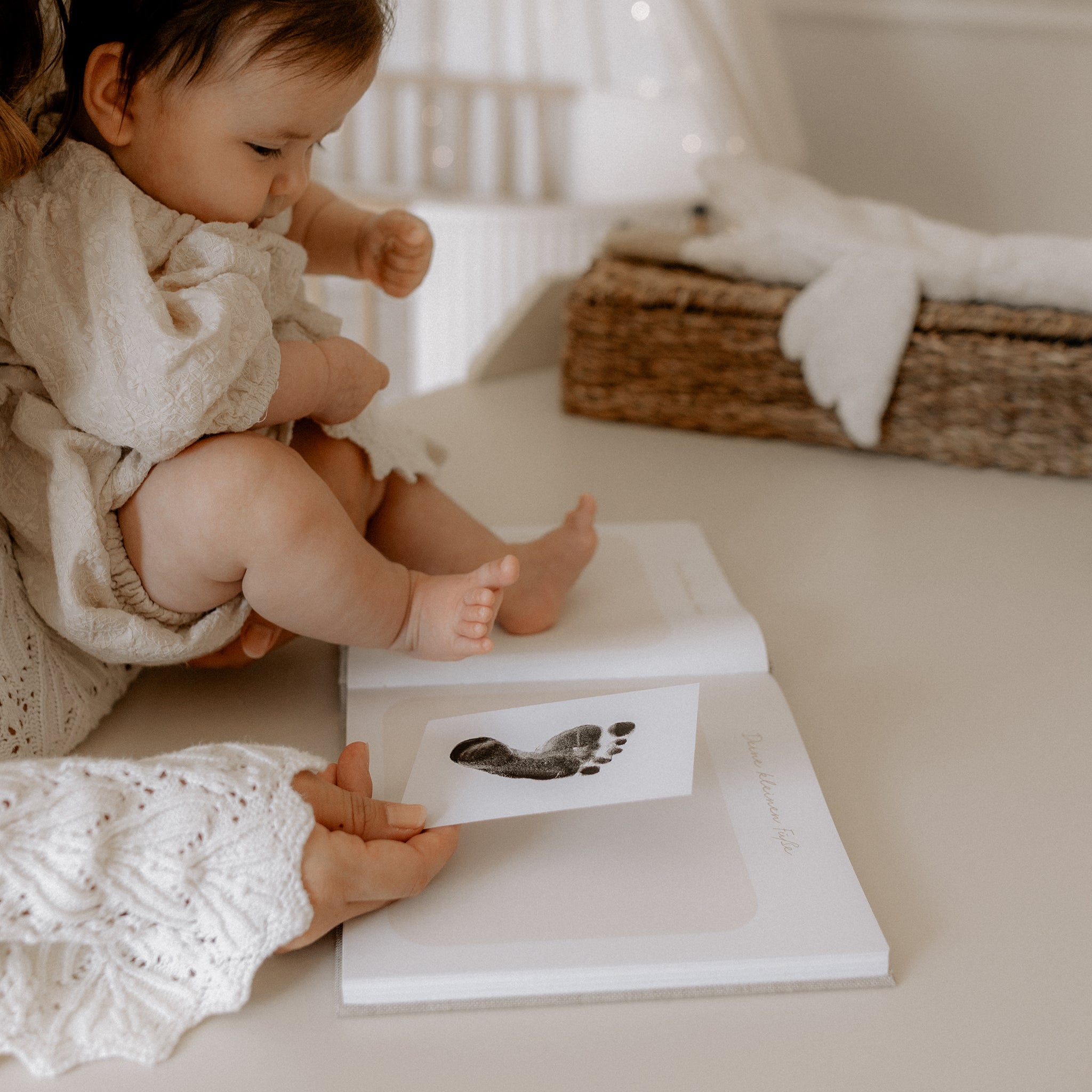 Fußabdruck eines Babyfußes wird in das Babybuch dein kleines Leben eingeklebt